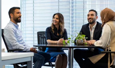 Four colleagues sitting around a table at the office